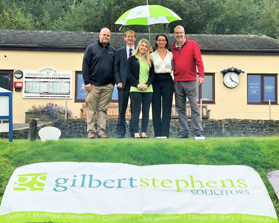 people at golf club under umbrella